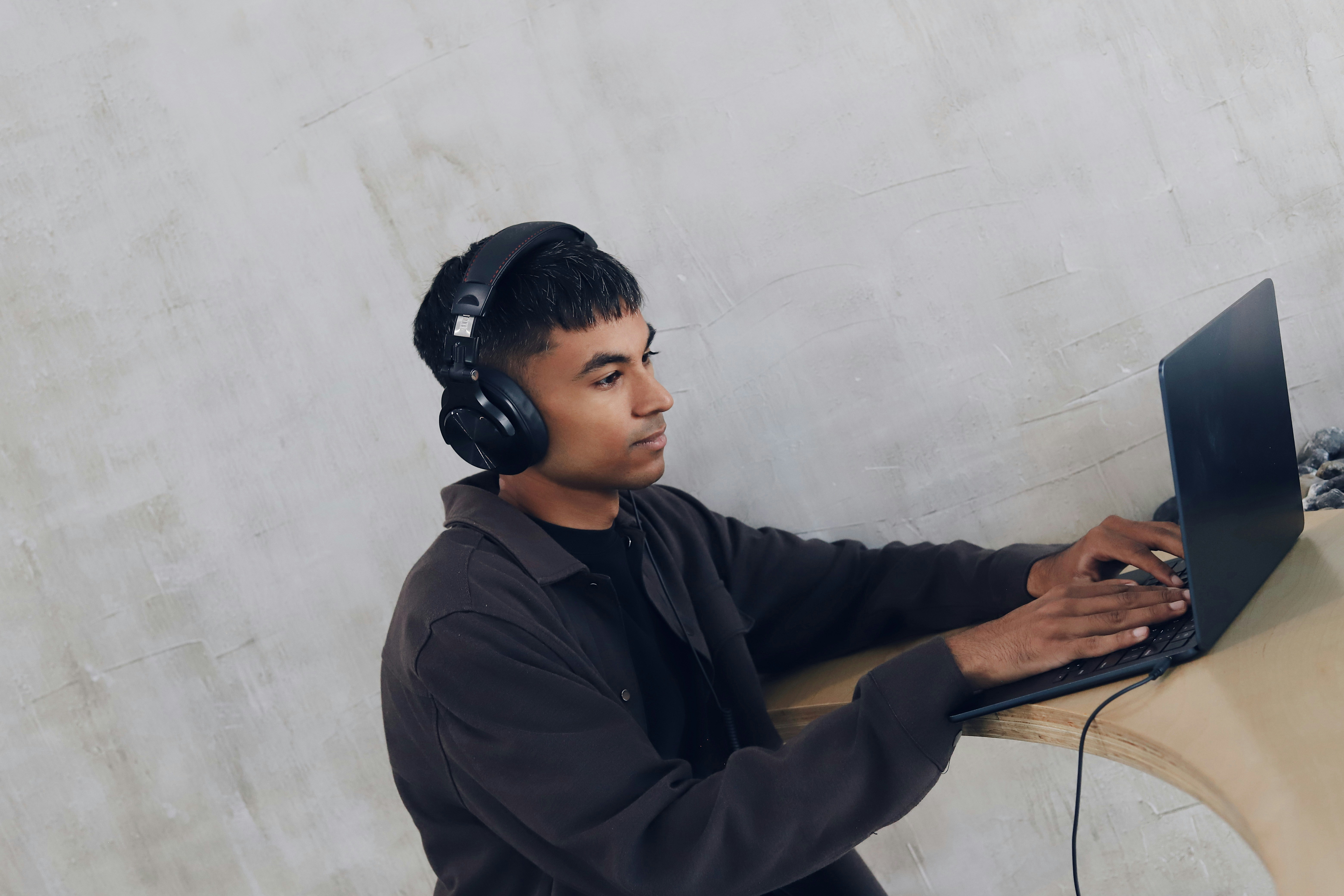 man working on laptop with headphones